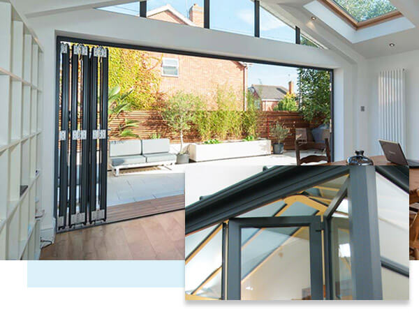 Looking through open, anthracite grey, bi folding doors, below a matching five pane glazed gable window and roof light in the vaulted ceiling.