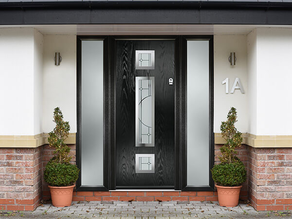 A black woodgrain Forte Composite front door, with frosted glass side panels, set in a matching frame, with 3 detailed glass panels in the door centre.