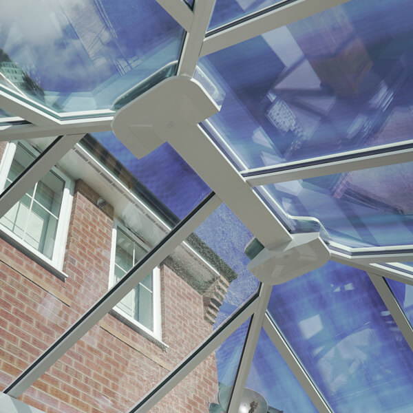 Looking Up Through A White Glass Roof Conservatory Roof With Blue Tinted Glass And White Roof Rafters.