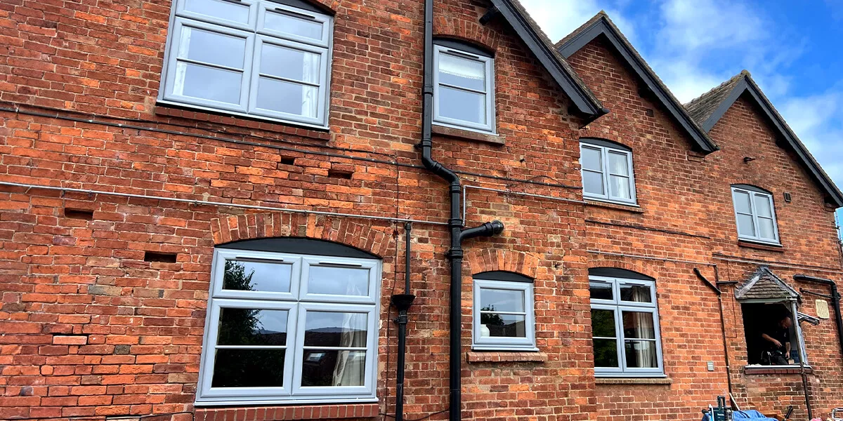 Installing six cottage style High Security, Extreme, Hazy Grey, UPVC double glazed Windows and an oriel bay into a red brick house.