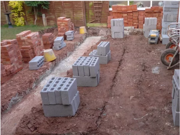 Concrete footing laid for conservatory with bricks and blocks ready to lay.