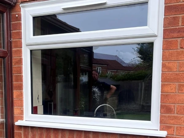 White UPVC window with a full width opening vent and a centre trickle vent above