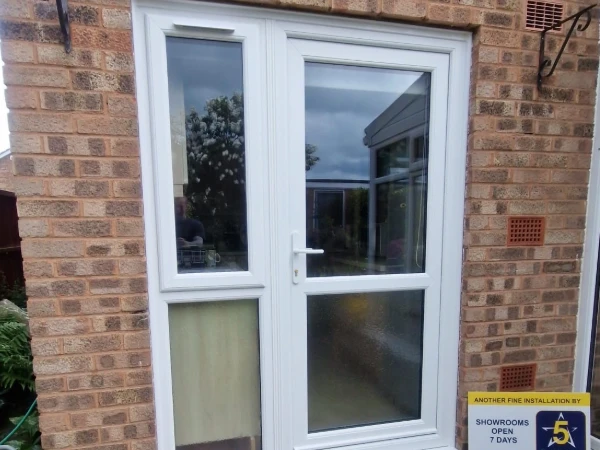 White upvc back door with matching side light and opening top window with trickle vent above