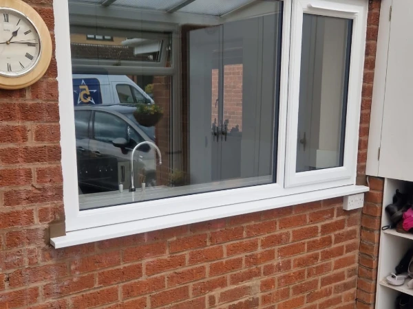 Window with trickle vents and reflection of 5 Star van showing in window