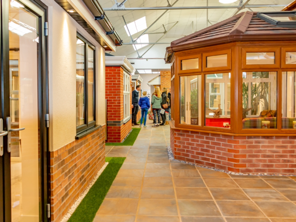 A family stand in the distance at the end of our showroom with a conservatory in the foreground