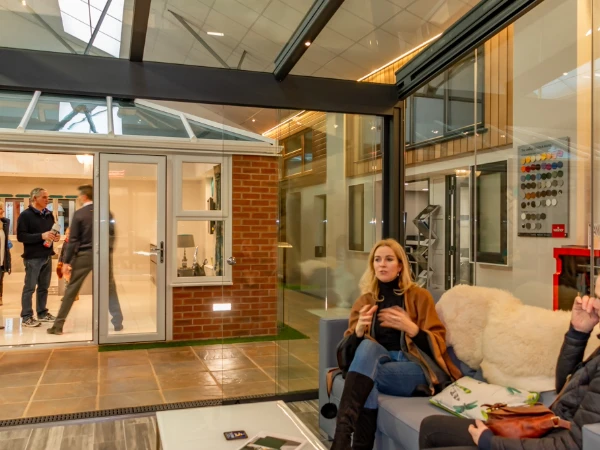 A lady sitting in a garden room looking across our indoor showroom