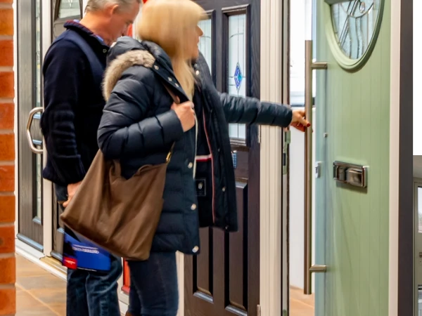 A lady opening one of a row of front doors in our showroom