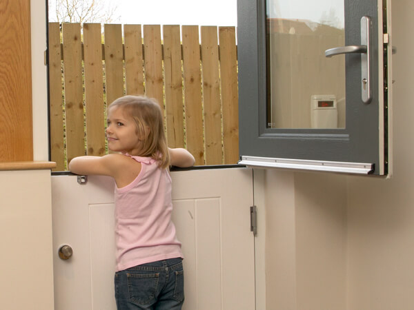 A Young Girl Leaning Out Of A Stable Doors